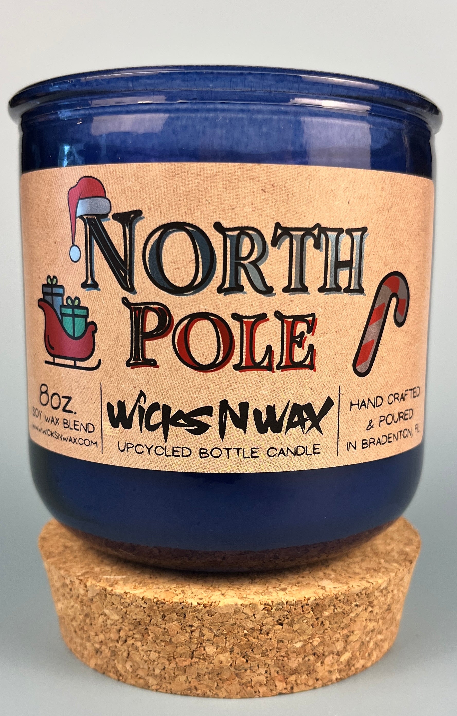 Recycled blue glass candle with cork base, North Pole label, WicksNWax branding.