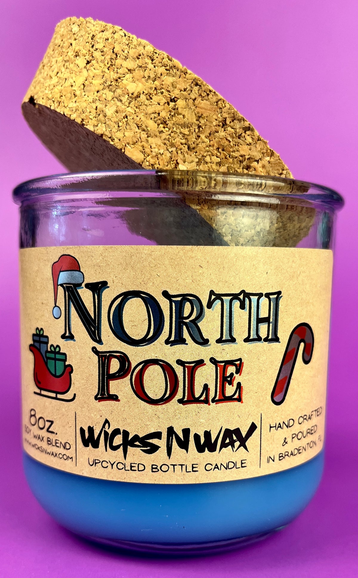 Recycled bottle candle with blue wax, kraft label, and cork base
