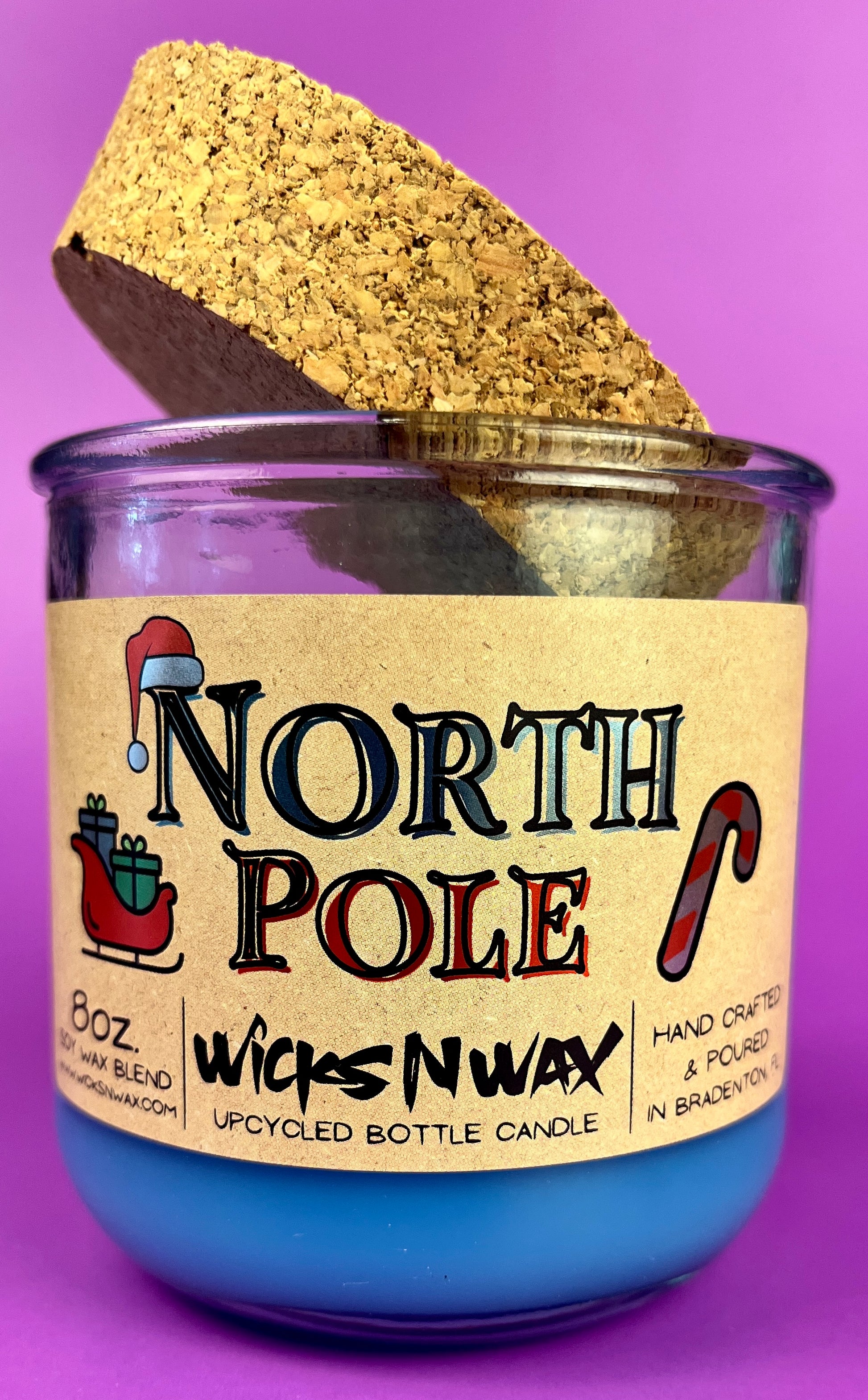 Recycled bottle candle with blue wax, kraft label, and cork base