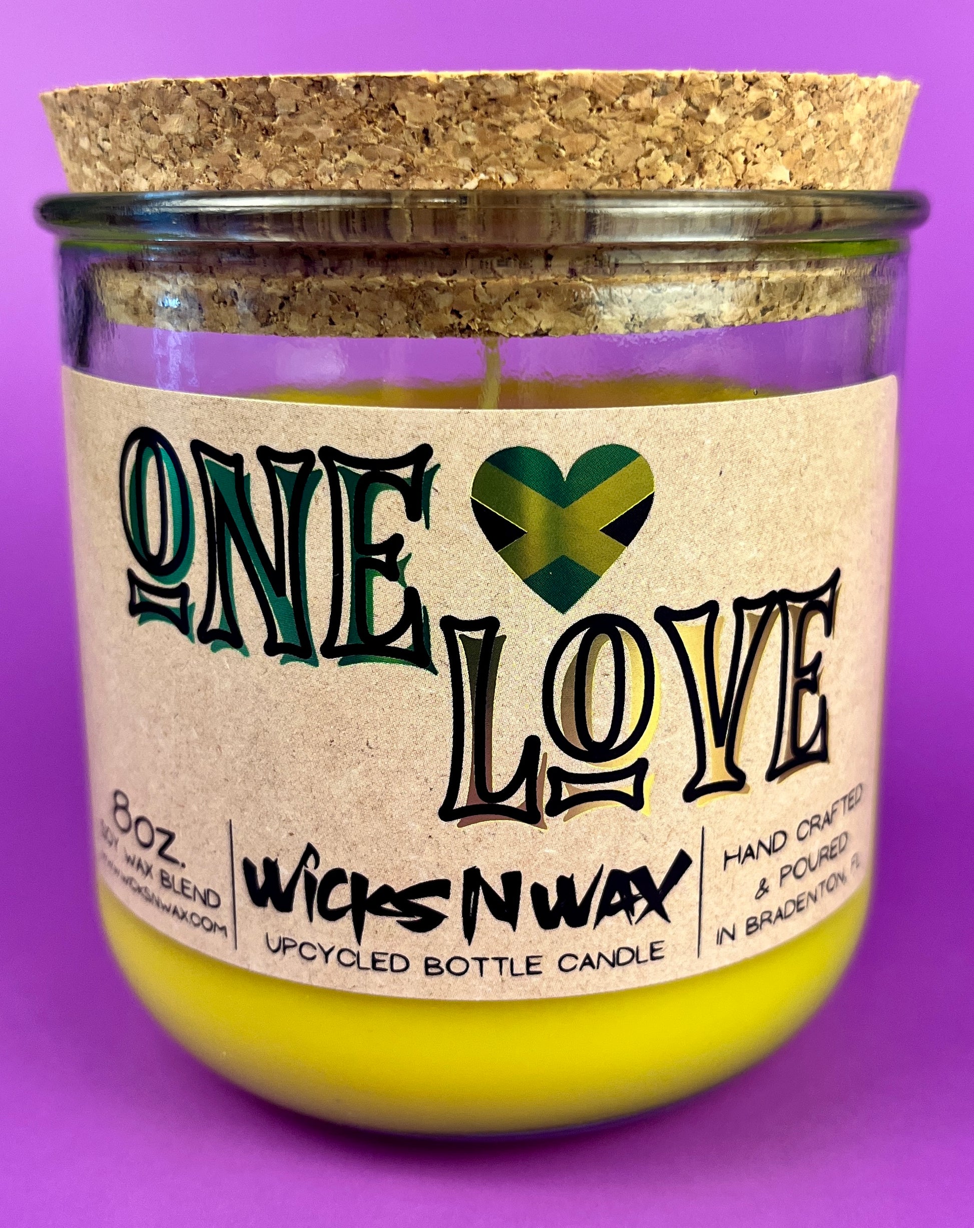 Recycled glass candle jar with cork base, yellow wax, One Love label.