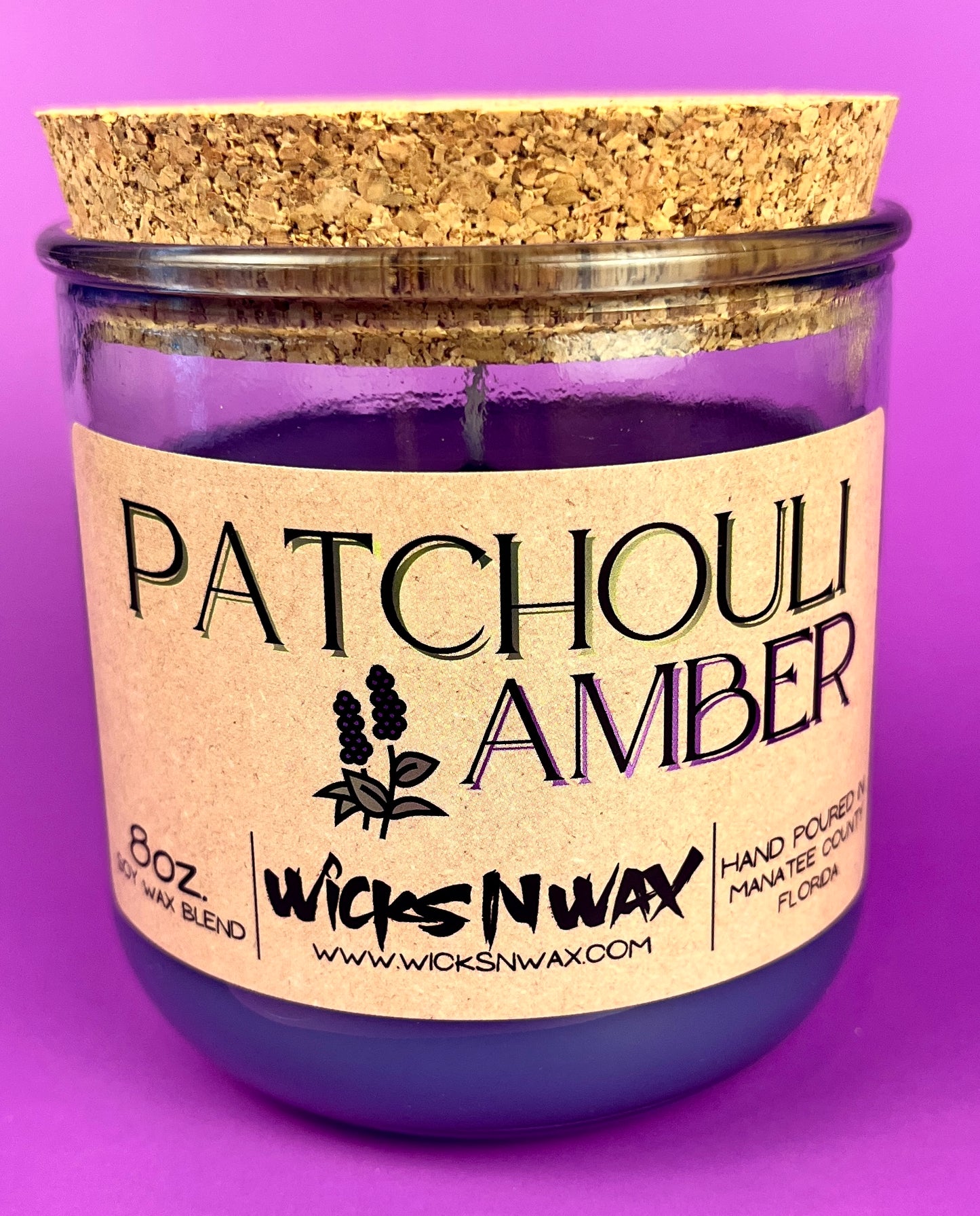 Recycled glass candle in clear jar with purple wax and cork lid, Patchouli Amber label.