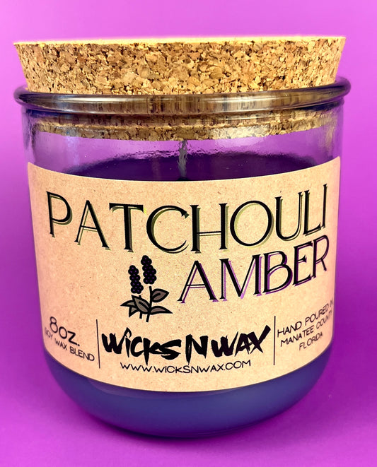Recycled glass candle in clear jar with purple wax and cork lid, Patchouli Amber label.