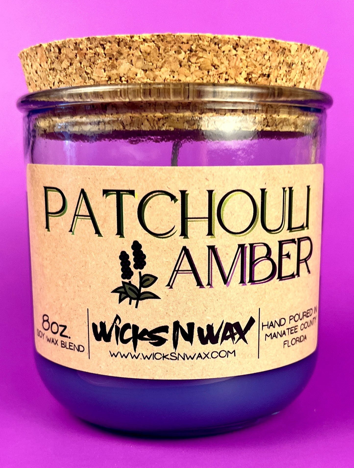 Recycled glass candle in clear jar with purple wax and cork lid, front label.