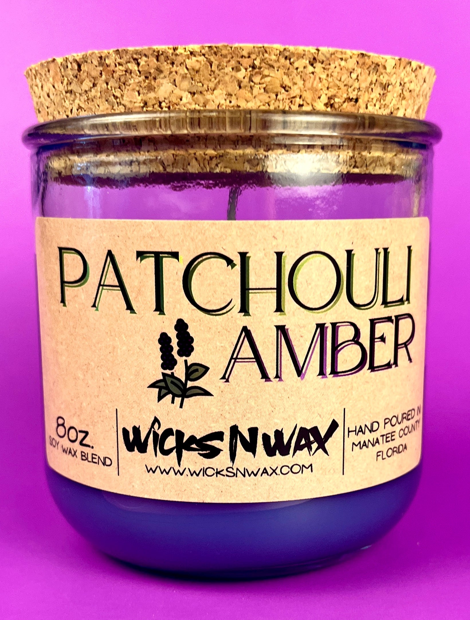 Recycled glass candle in clear jar with purple wax and cork lid, front label.
