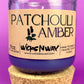 Recycled glass candle in clear jar with purple wax and cork base, front label visible.