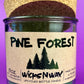 Pine Forest recycled glass candle jar with green wax and front label, cork base