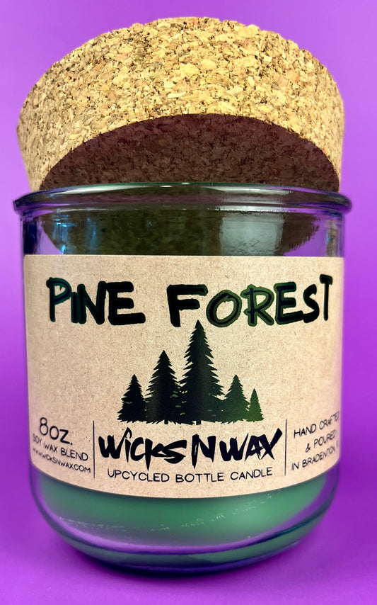 Pine Forest recycled glass candle jar with green wax and front label, cork base