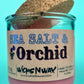 Recycled glass candle with cork lid, pink wax, blue-and-black printed label