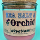 Recycled glass candle close-up, pink wax with cork lid, blue-and-black label