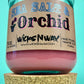 Recycled glass candle with cork lid below, pink wax, blue-and-black printed label