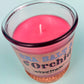 Recycled glass candle with pink wax, centered wick, cork base visible