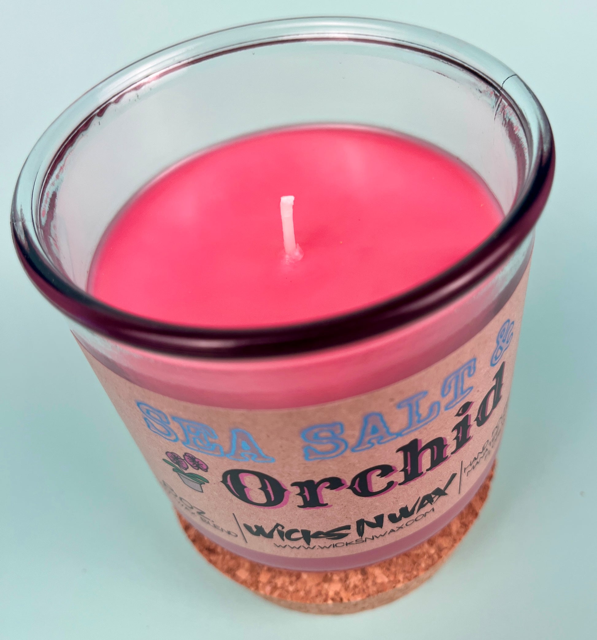 Recycled glass candle with pink wax, centered wick, cork base visible