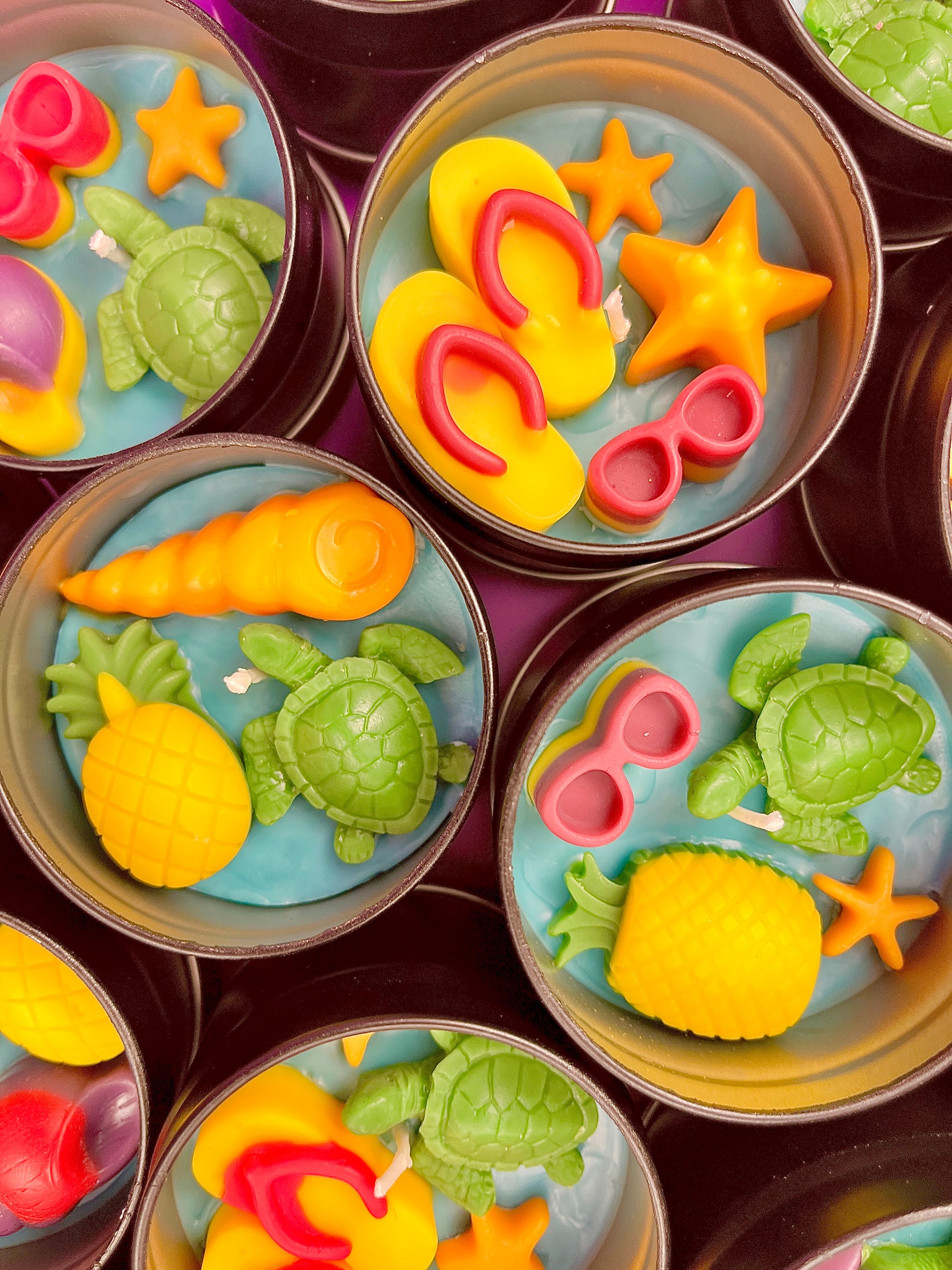 Small sea-themed wax tins with starfish, shells, and green sea turtle pieces in blue wax