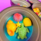 Small round wax melt tin with sea turtle, yellow shells, starfish, and pink shell