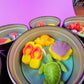 Large metal candle tin featuring yellow footprints, purple shell, and green turtle wax