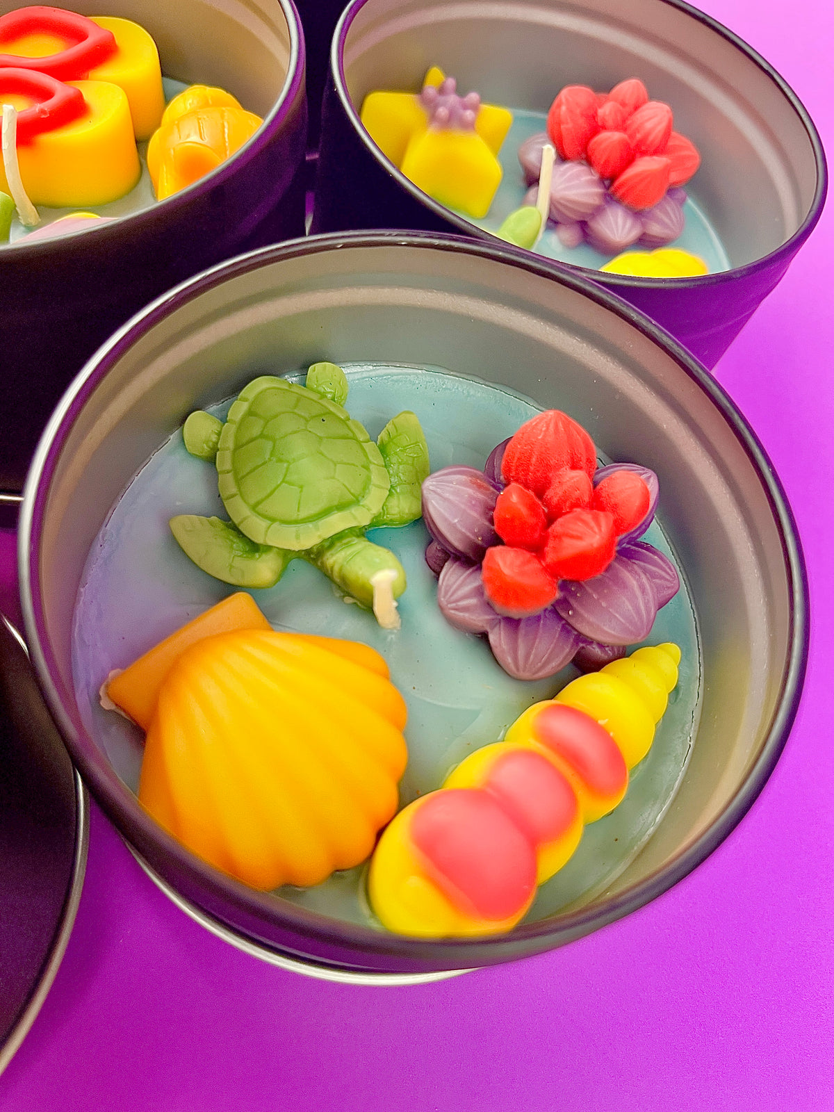 Large Sea Art tin with turtle, orange shell, and coral-flower wax pieces