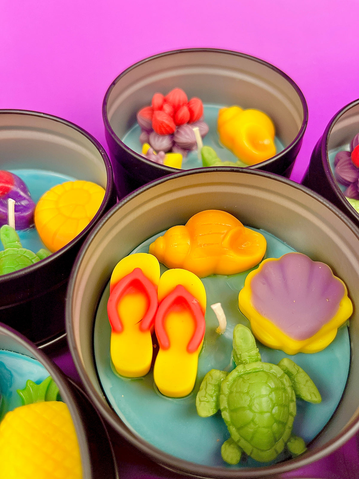 Metal candle tin set with sea-themed wax shapes in yellow, purple, green, and red