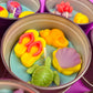 Large metal candle tin with colorful sea-themed wax shapes and visible wicks