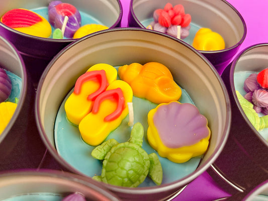 Large metal candle tin with colorful sea-themed wax shapes and visible wicks