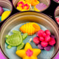 Large metal candle tin with orange shell, pink flower, yellow star, and green turtle wax