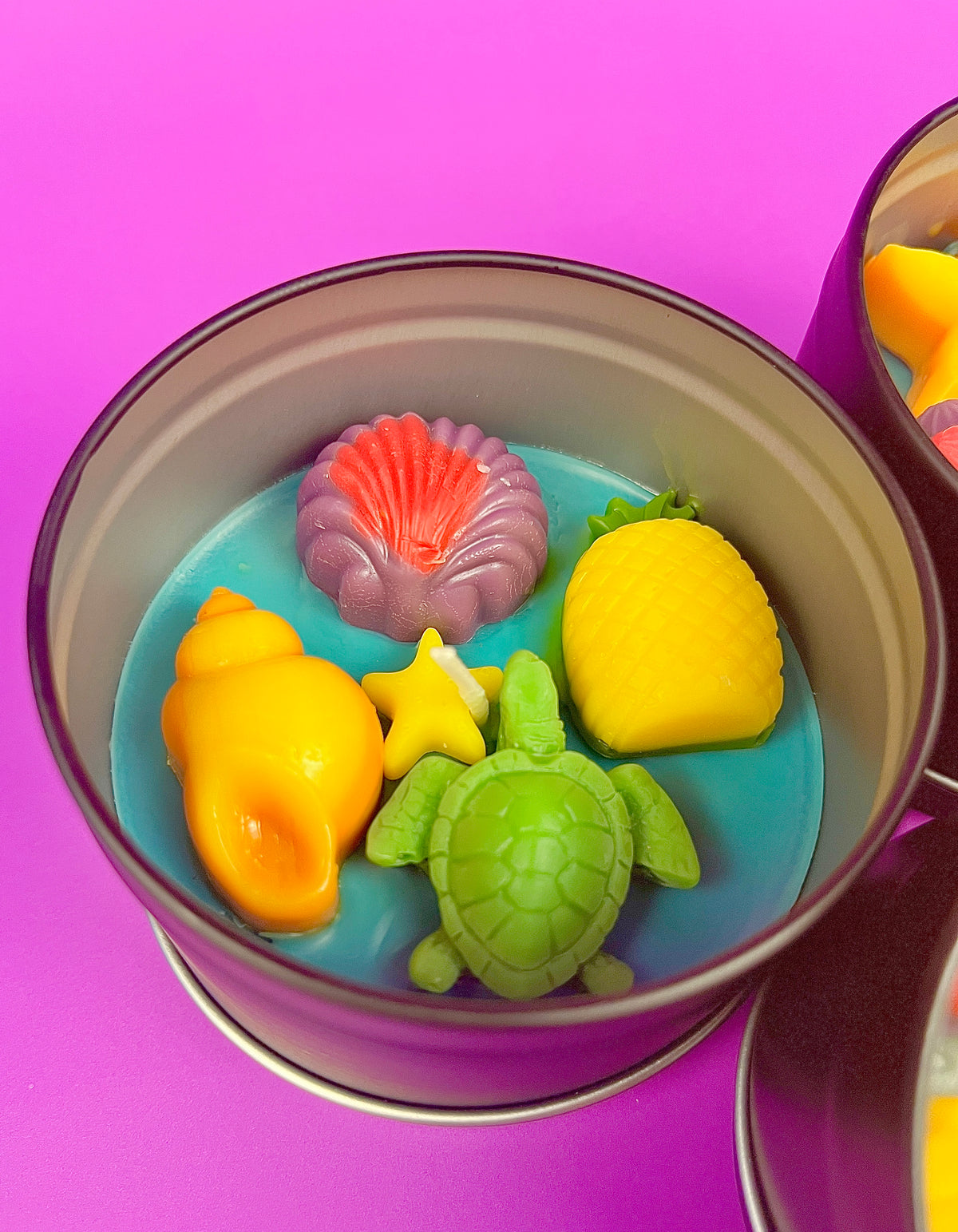 Large metal candle tin with blue wax base and yellow and green sea creatures