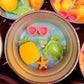 Small round wax melt tin with yellow shell, sea turtle, starfish, and pink bow accents