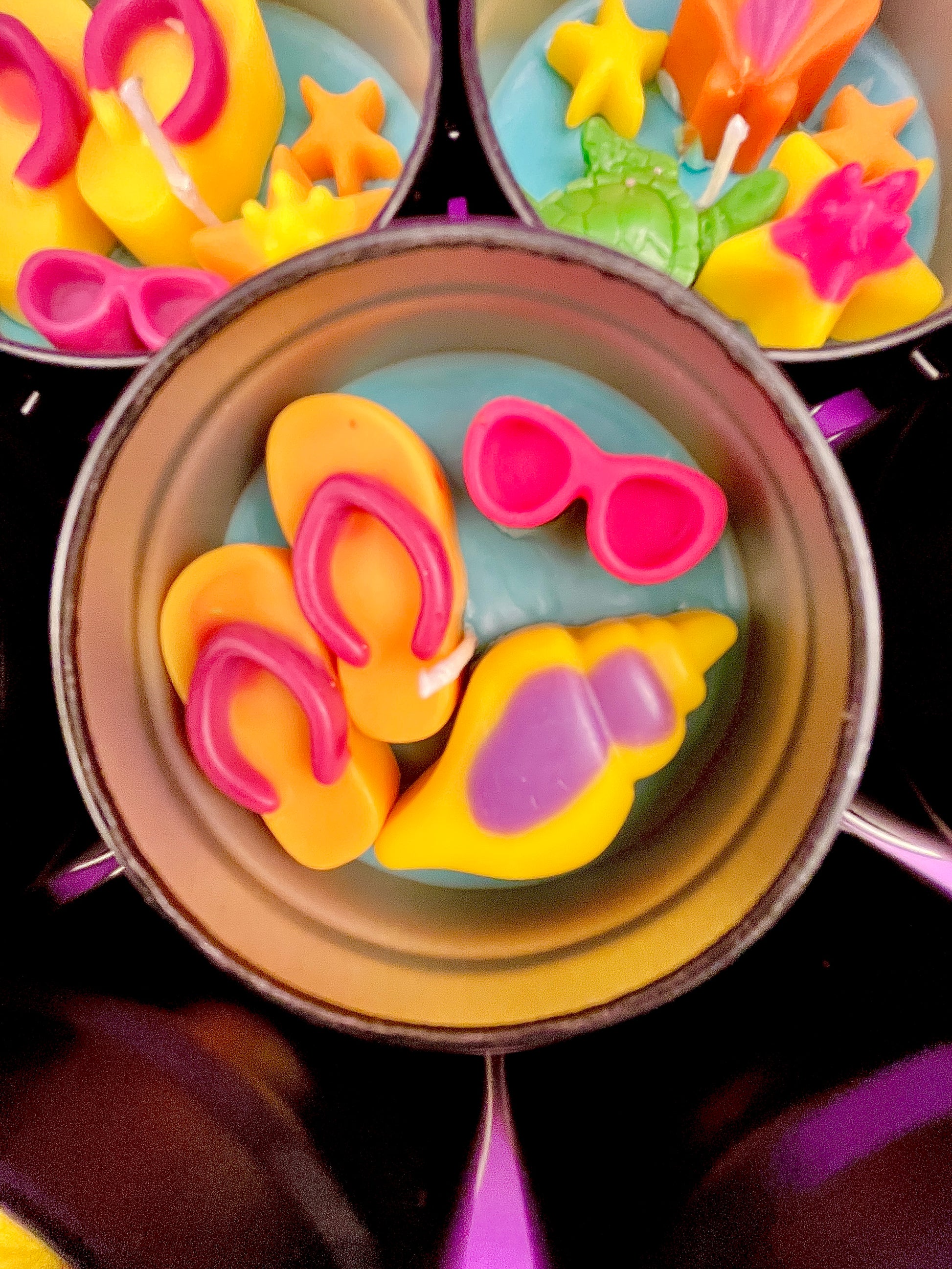 Small round wax melt tin with pink bow shells and orange and yellow sea shapes