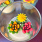 Small cactus art candle close-up: clear glass with colorful cactus wax shapes