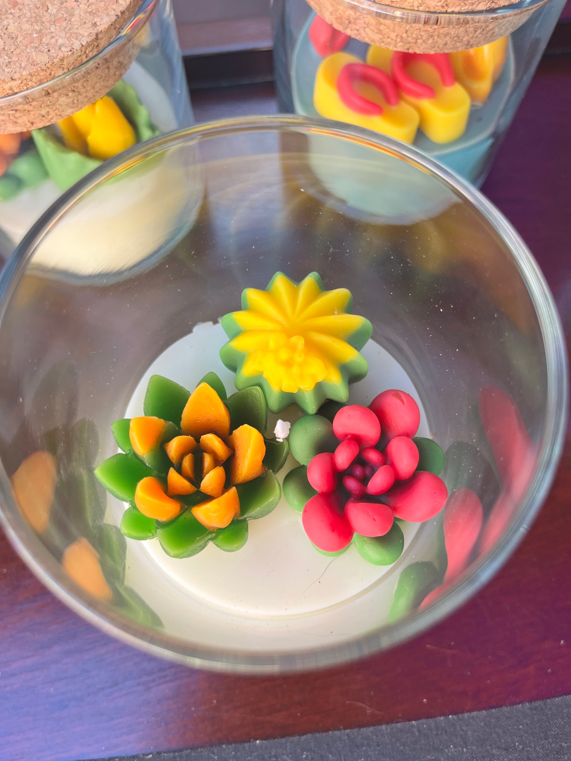 Small cactus art candle close-up: clear glass with colorful cactus wax shapes