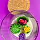 WicksNWax cactus art candle with cork lid and small purple and pink flower wax in glass