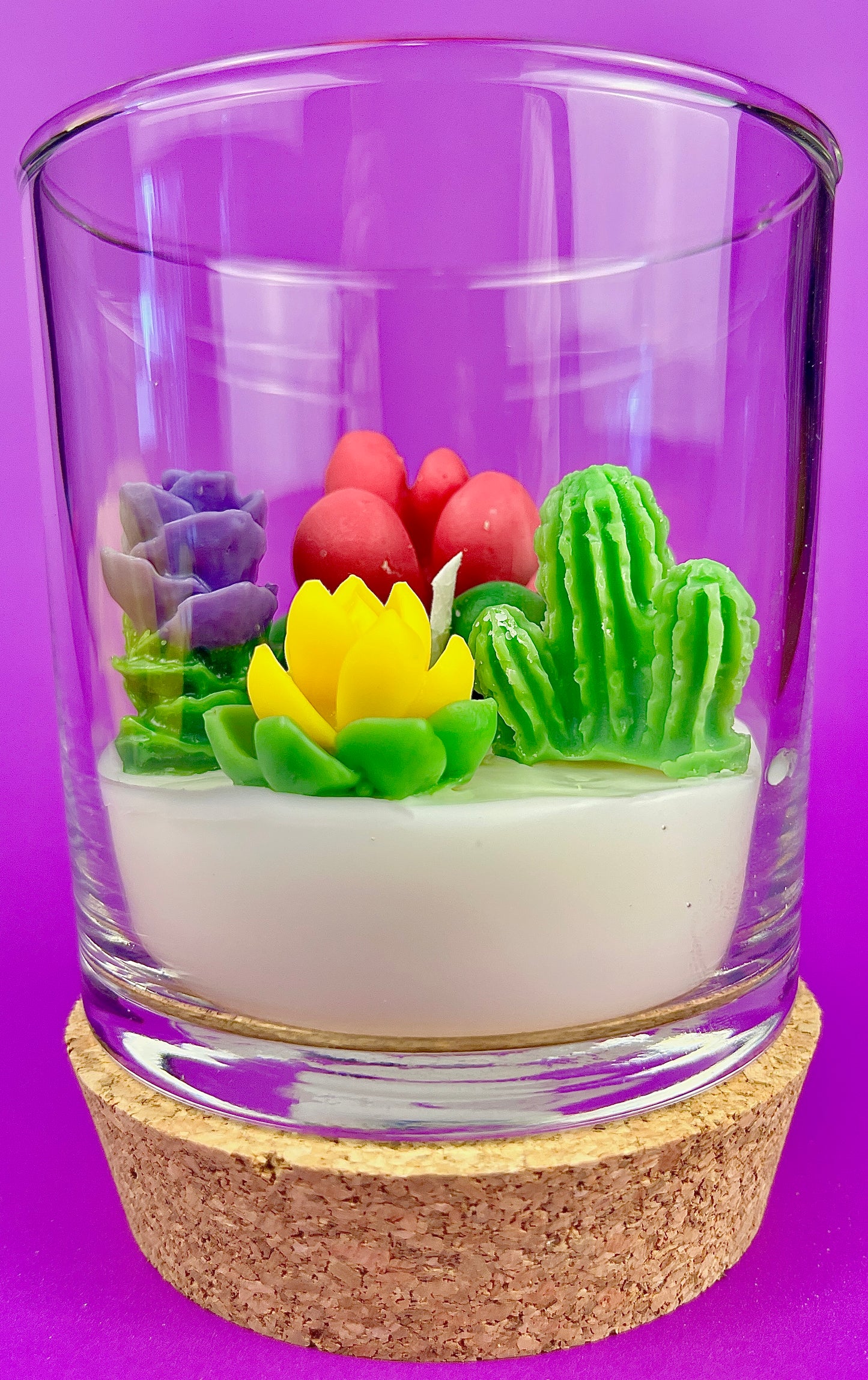WicksNWax cactus art candle in clear glass with green, purple, yellow, and pink wax cacti