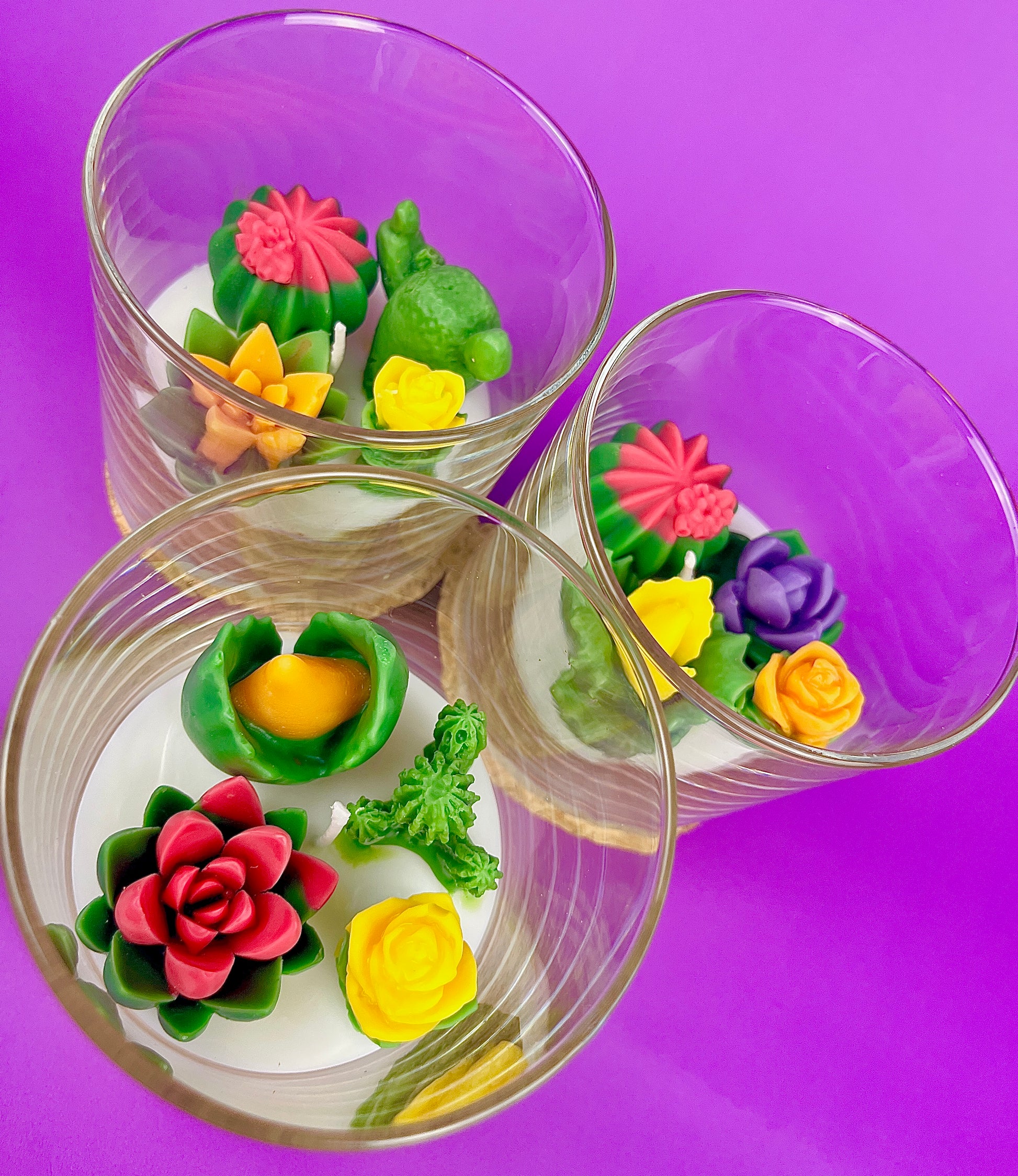 Small cactus art candle in glass jar with red, yellow and green flower wax details