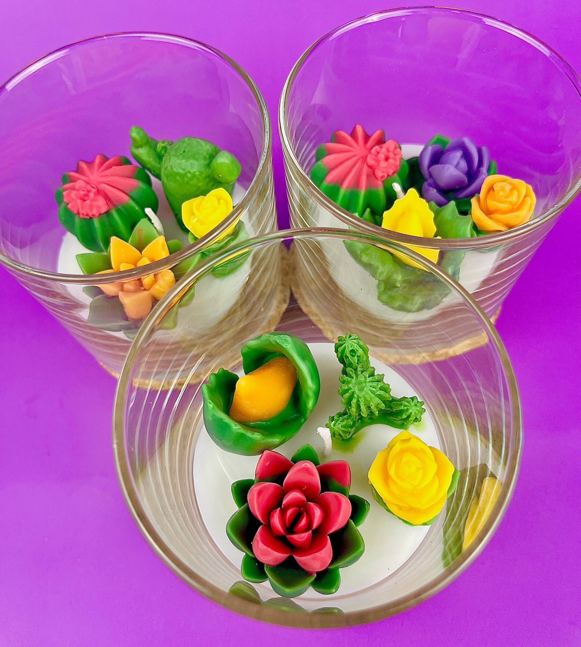 Small cactus art candle in glass jar with green, yellow and pink wax flowers