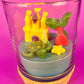 Small candle in glass with cork base, featuring castle and mermaid-shaped wax