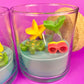 Small scented candle in clear glass jar with star and coral-like wax topper