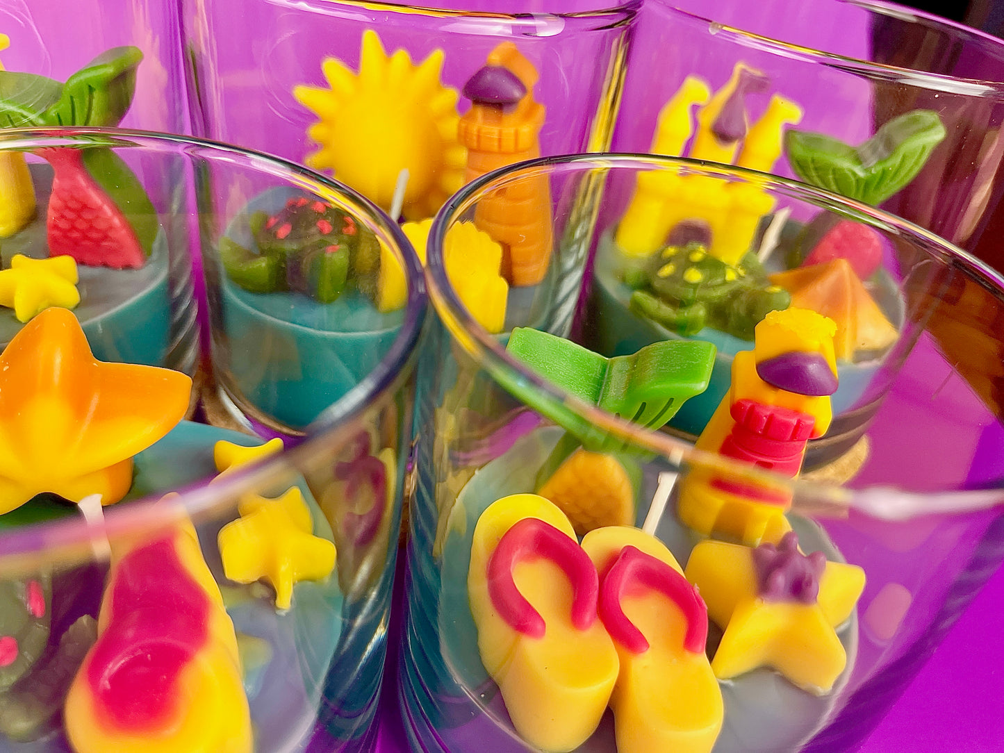 Small scented candle set in clear glass jars with colorful sea-themed wax figures
