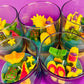 Small scented candle set in clear glass jars with assorted colorful wax shapes