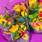 Small candles in glass with colorful shell and star-shaped wax pieces inside