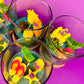 Small candle in glass container with assorted star and shell-shaped wax pieces
