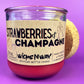 Recycled bottle candle with cork base, red wax, 'Strawberries & Champagne' label.