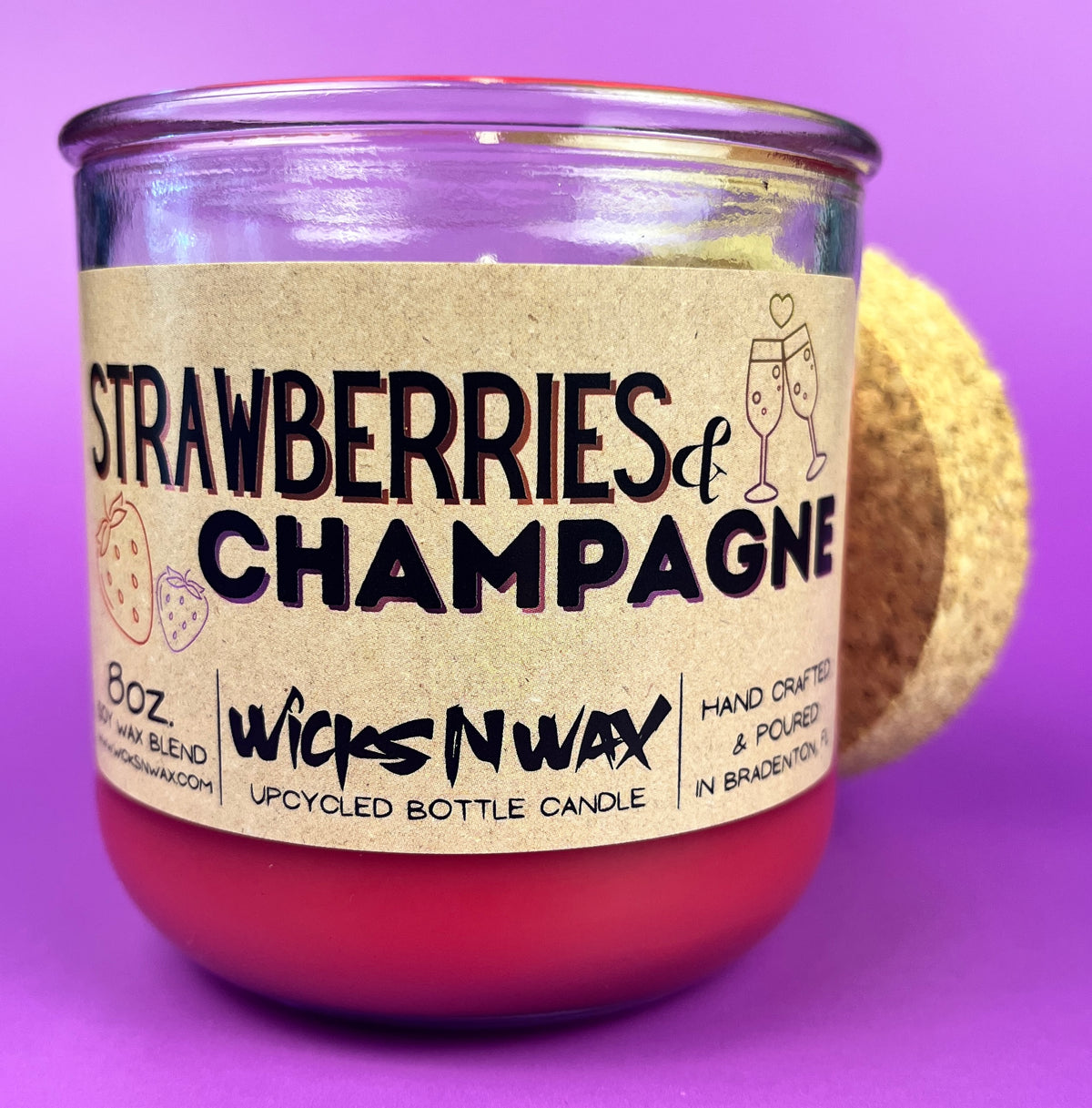 Recycled bottle candle with cork base, red wax, 'Strawberries & Champagne' label.