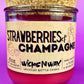 Recycled glass candle jar with red wax, 'Strawberries & Champagne' front label.