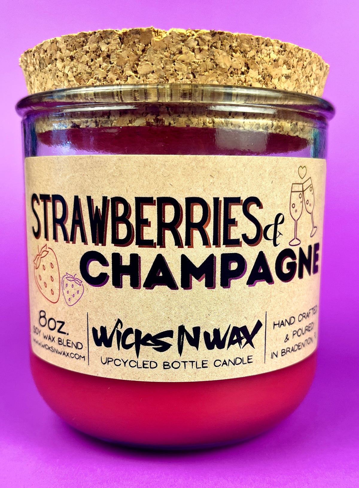 Recycled glass candle jar with red wax, 'Strawberries & Champagne' front label.