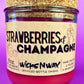 Recycled glass candle with cork base, red wax, 'Strawberries & Champagne' label.
