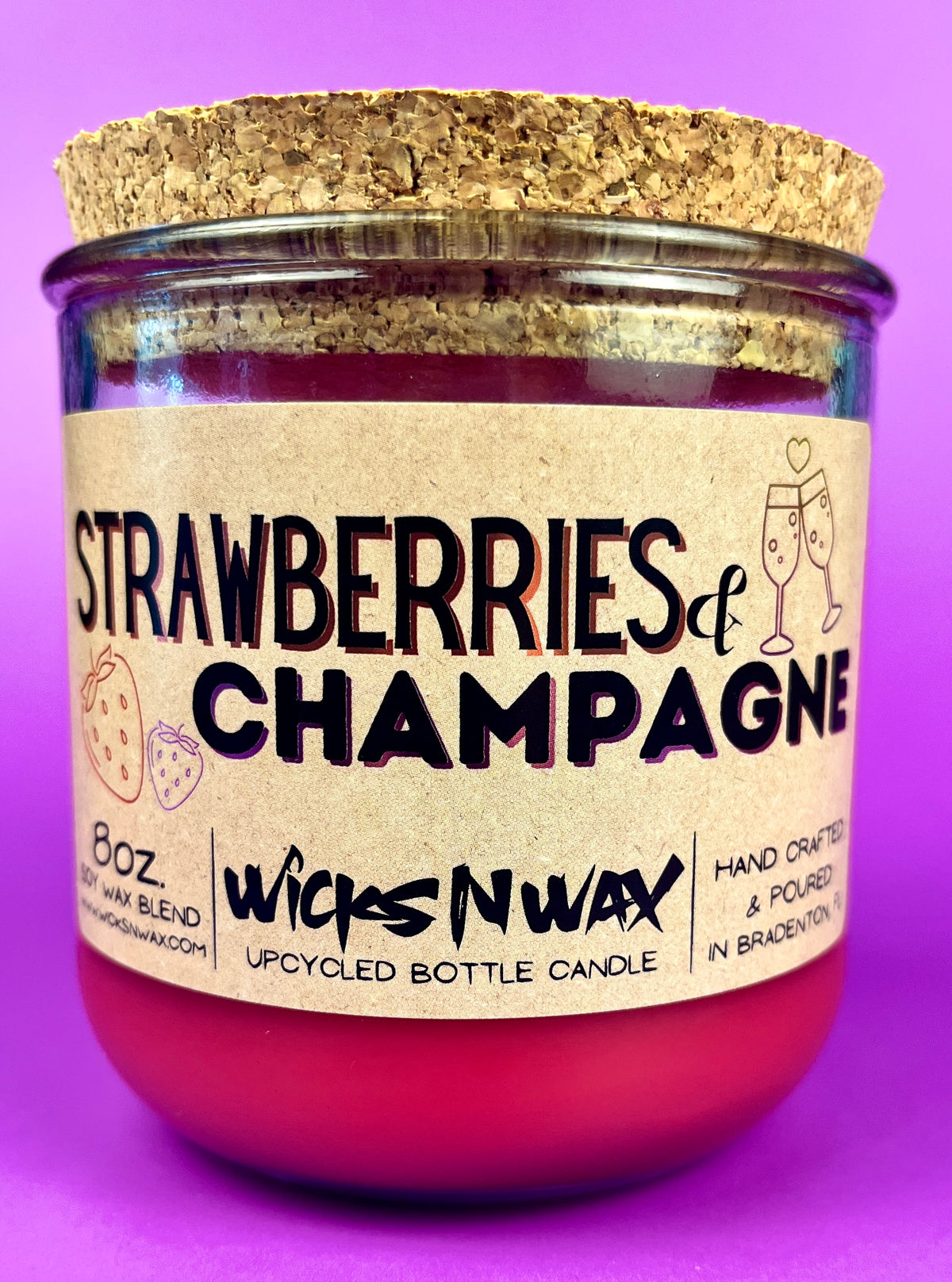 Recycled glass candle with cork base, red wax, 'Strawberries & Champagne' label.