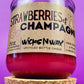 Recycled glass candle with cork base, red wax, 'Strawberries & Champagne' label.