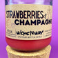 Recycled glass candle with cork base, red wax, 'Strawberries & Champagne' label.
