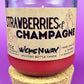 Recycled glass candle jar, red wax, 'Strawberries & Champagne' label, with cork base.