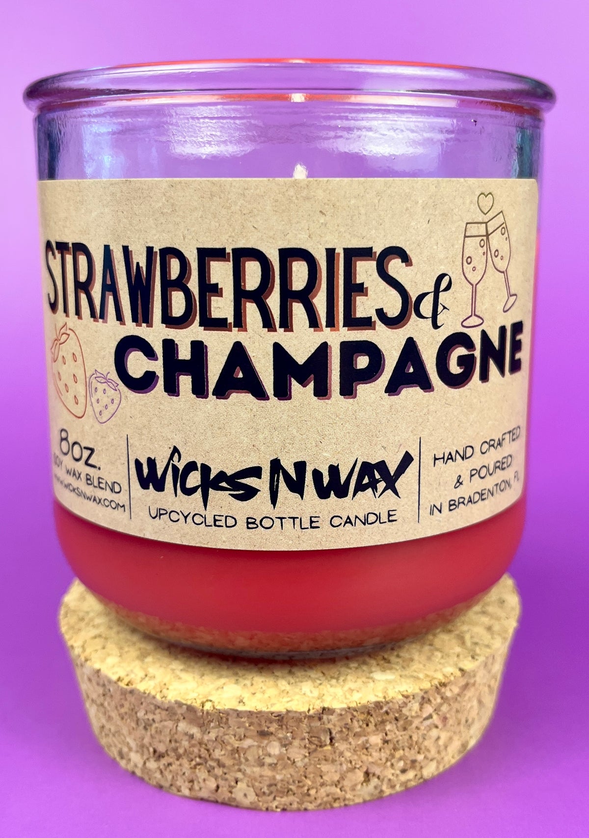Recycled glass candle jar, red wax, 'Strawberries & Champagne' label, with cork base.
