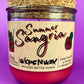 Recycled glass bottle candle with red wax, cork lid, and printed label on jar
